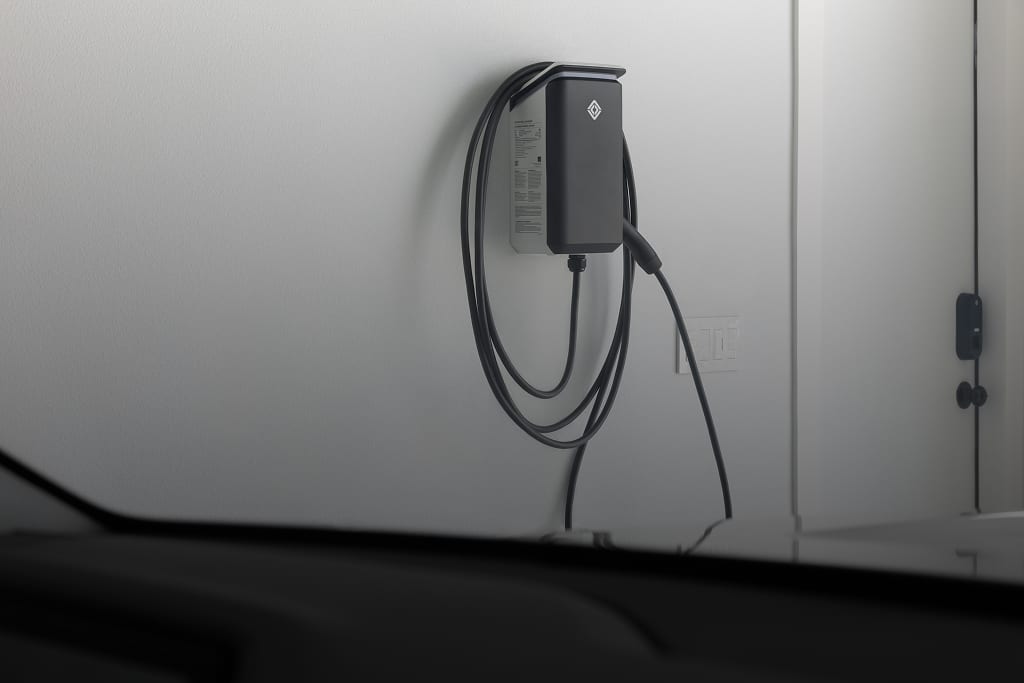 Rivian Wall Charger installed on a white wall of a garage.