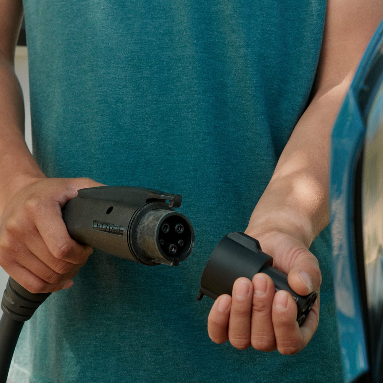 A person attaching a charging adapter to a charging cable.