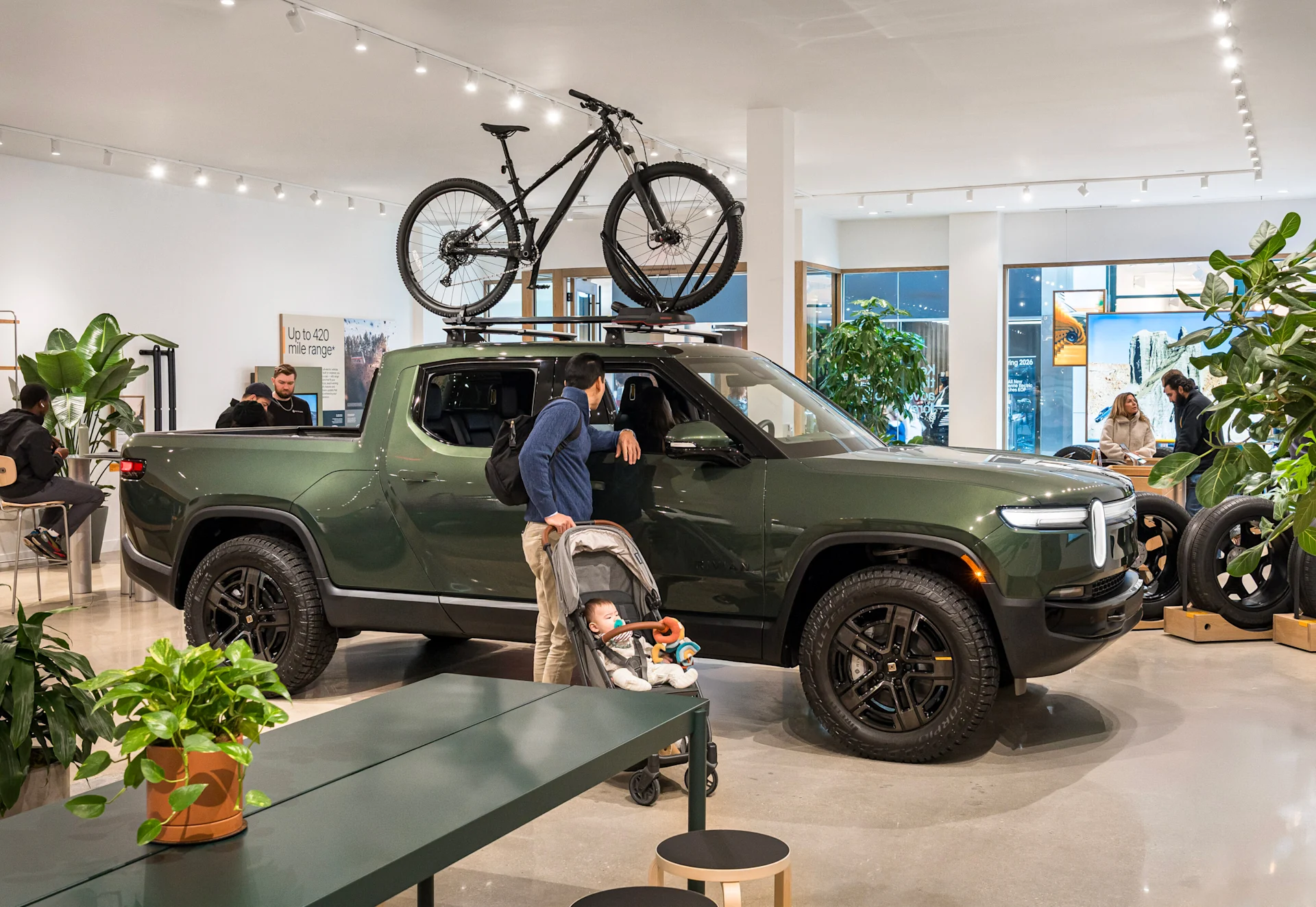 A dark green Rivian R1T electric truck on display inside the Rivian King of Prussia Space