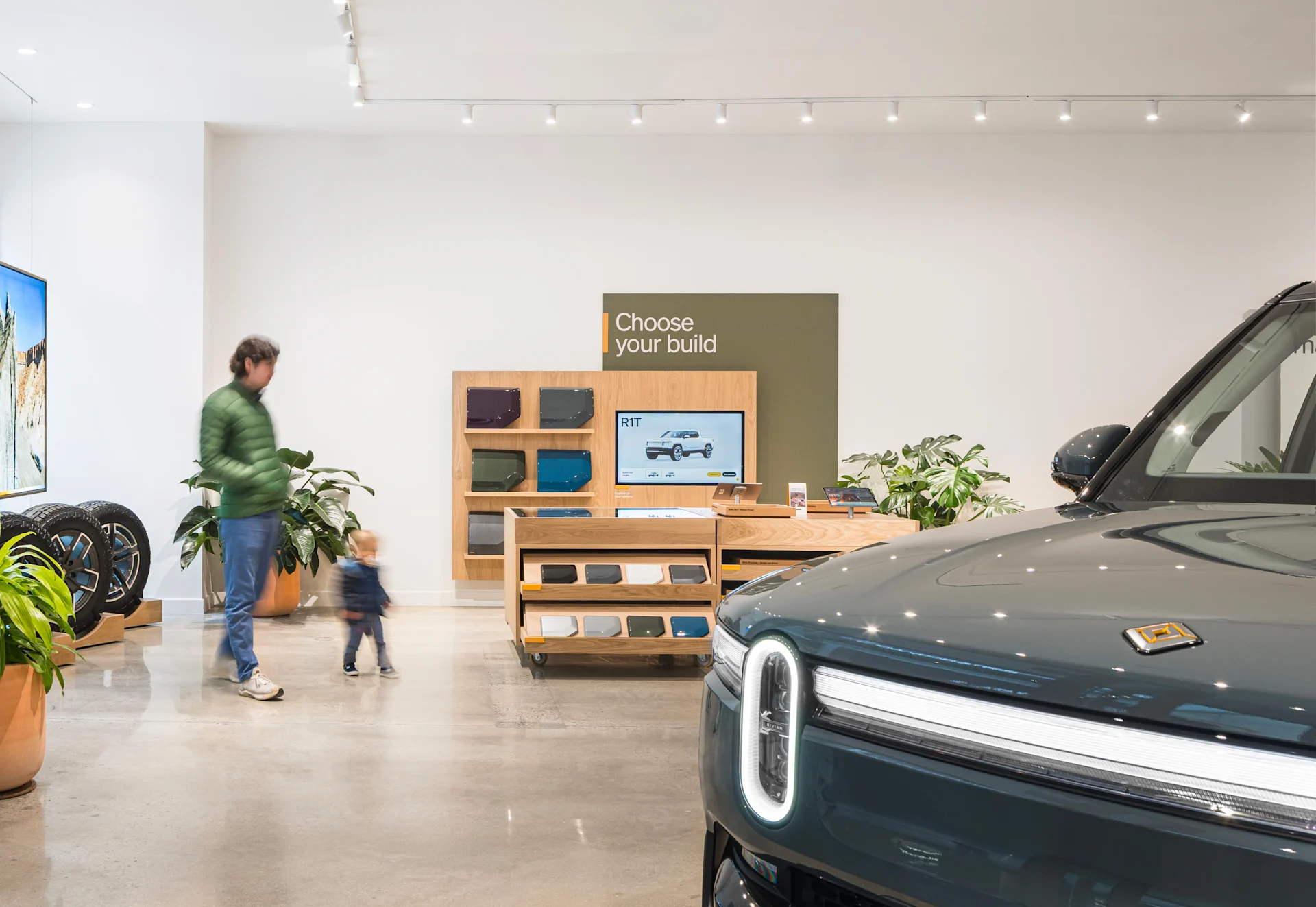 A father and child walking inside the Rivian King of Prussia Space