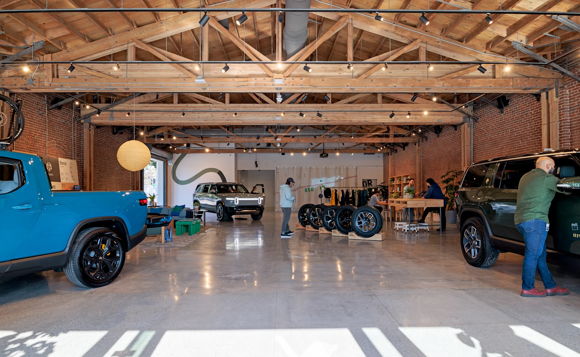People talking with Rivian R1T on background