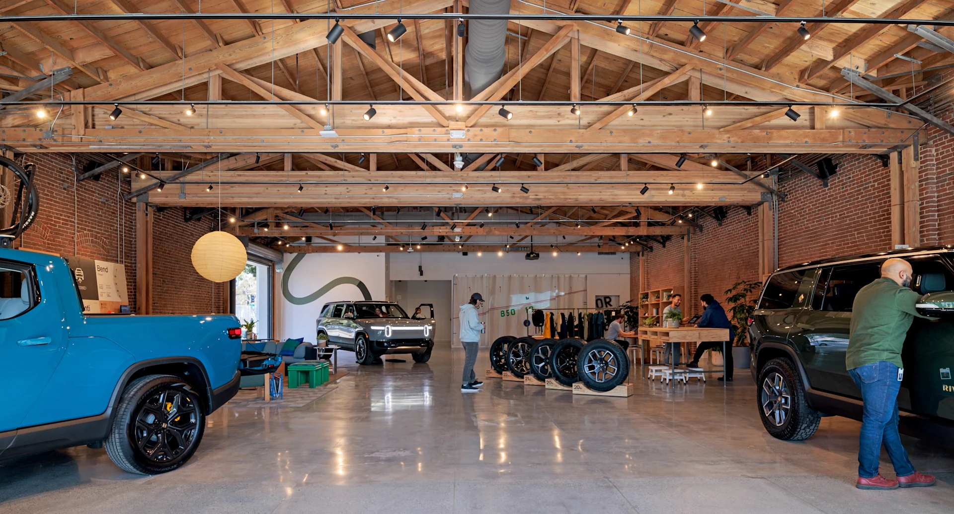 People talking with Rivian R1T on background