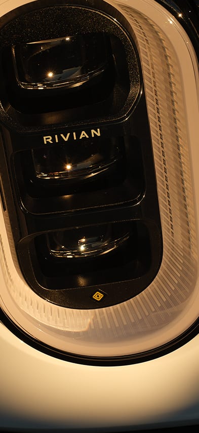 An extreme close-up of a White Rivian R2 electric SUV headlight