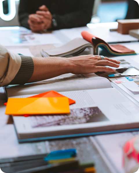 Close up shot of hands touch blue prints and color swatches for the development of the Performance House, in partnership with Mikaela Shiffrin.