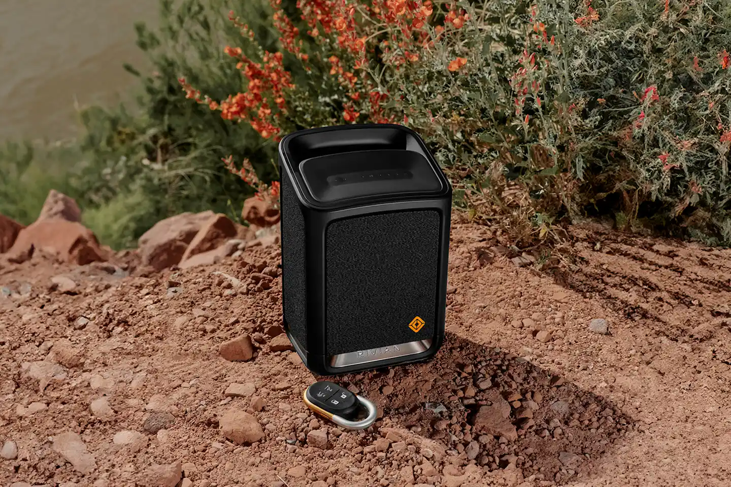 The Rivian Camp Speaker, with desert flowers in the background.