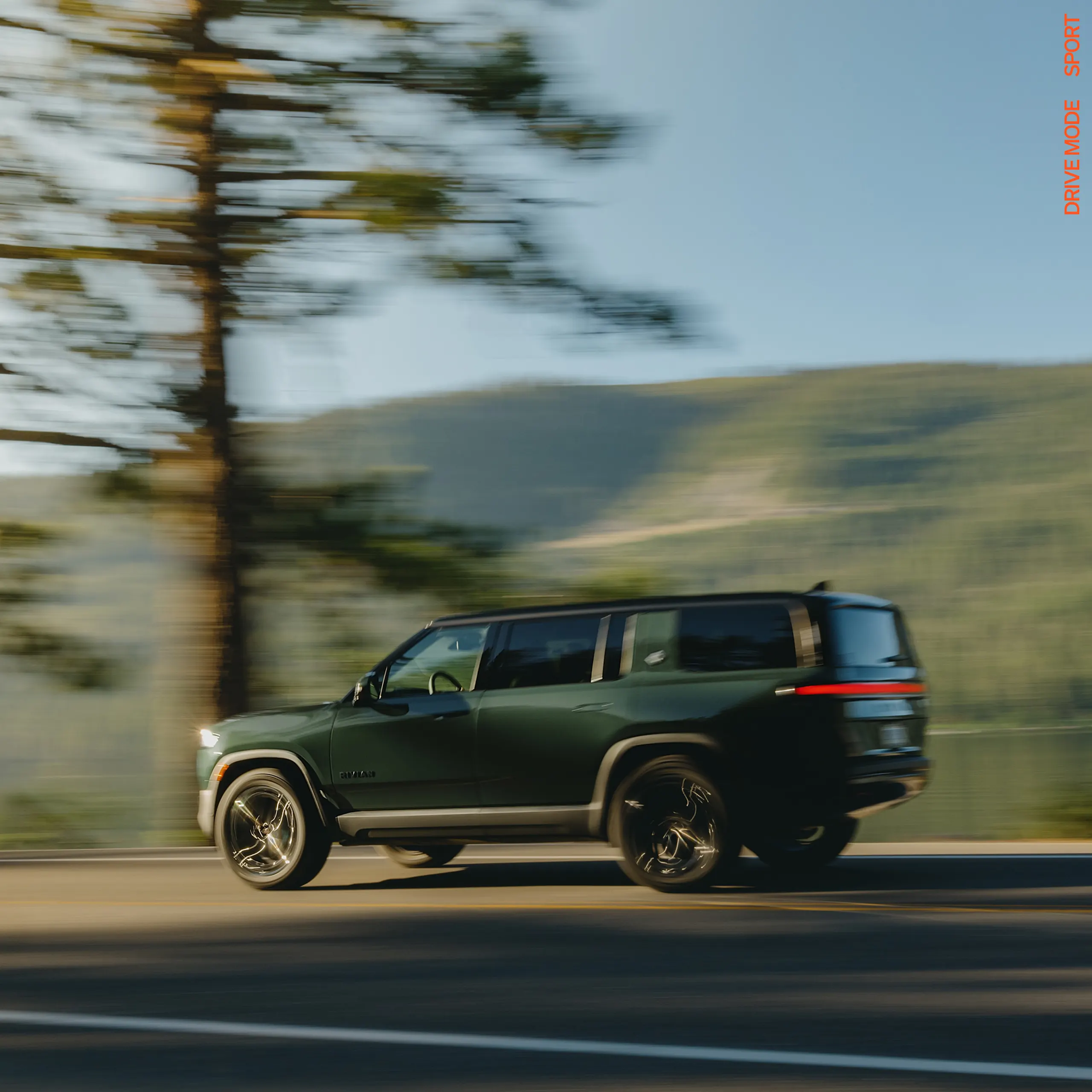 An action shot from a low point-of-view of the front driver side wheel. The wheel features rugged tires and 20” Dune Satin Graphite All-Terrain wheels. 